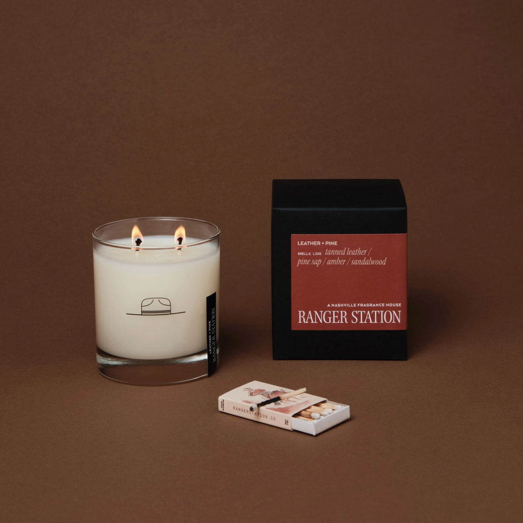 Candle with matches and packaging on a brown background