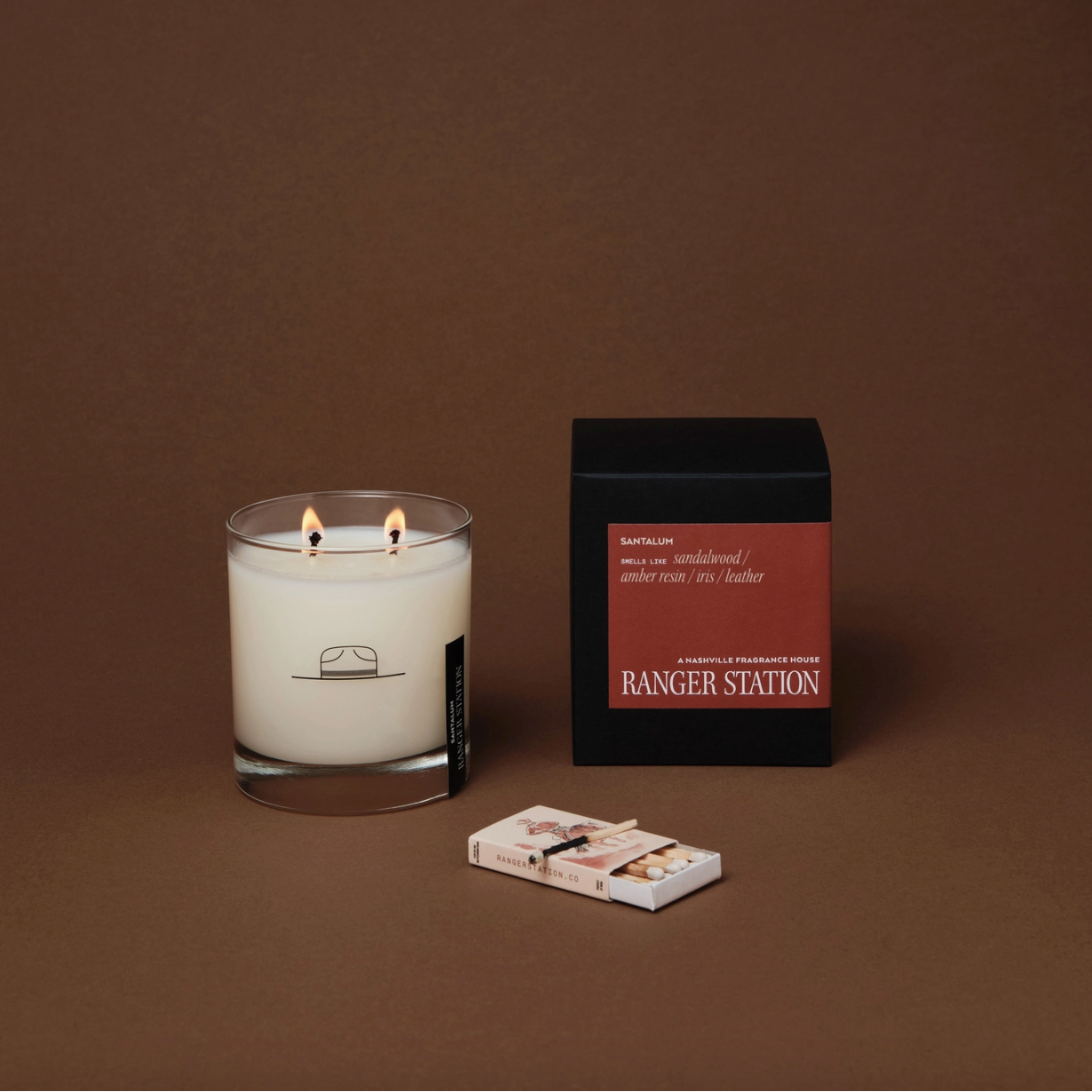 Candle with matches and packaging on a brown background