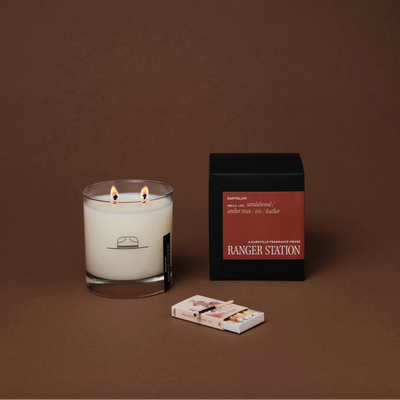 Candle with matches and packaging on a brown background
